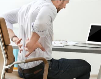 a worker holding his back because he suffering from a work injury at work
